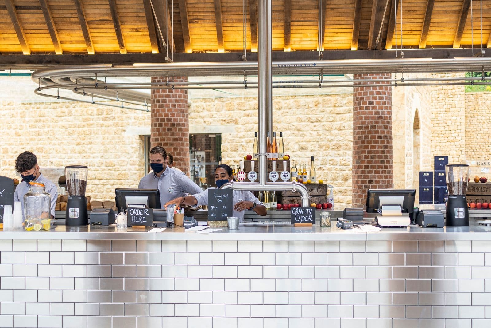 Team serving customers at a coffee shop counter. Photo by James Frid (Pexels)