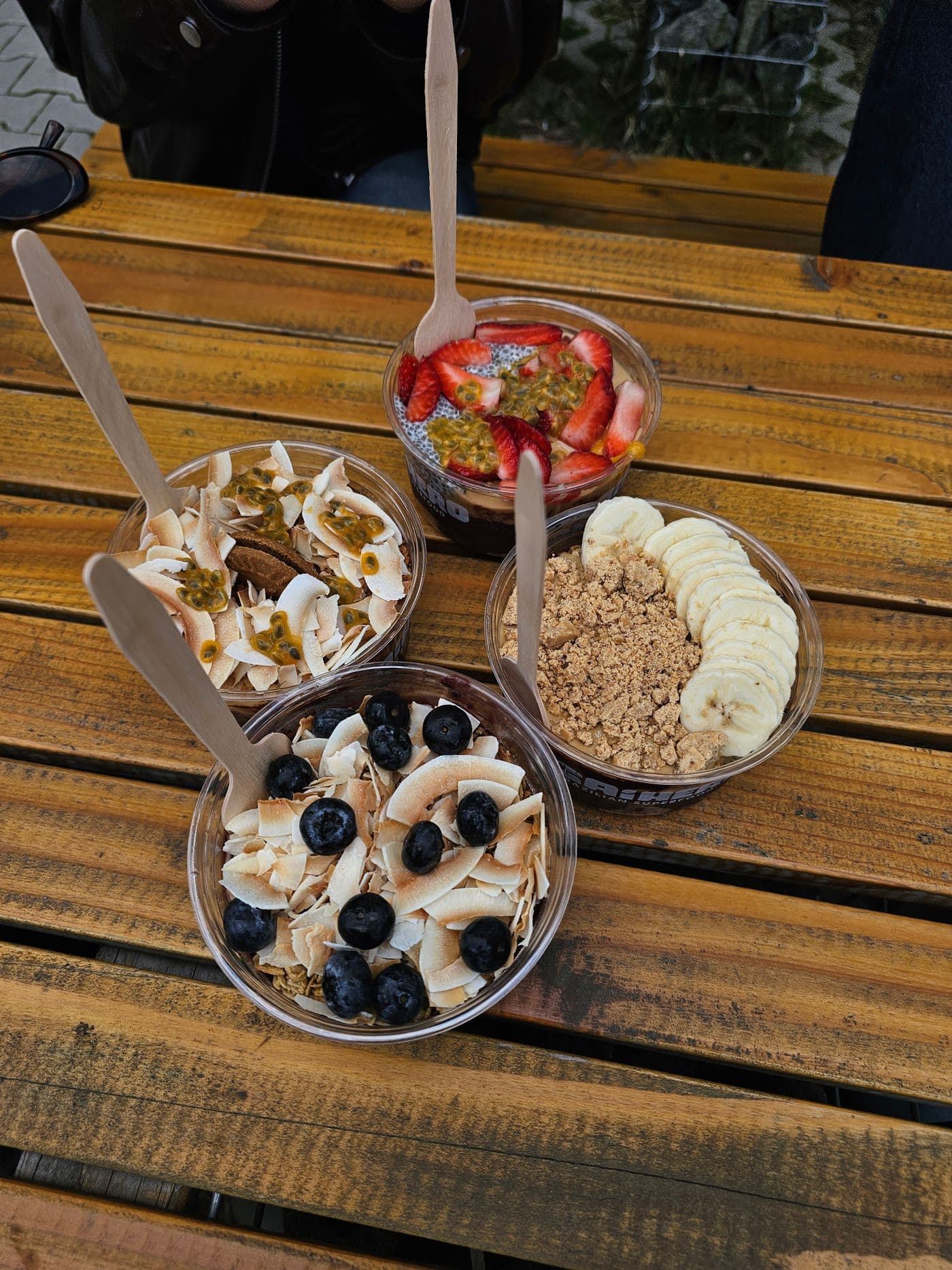 Several açaí bowls with different toppings on a wooden table. Photo by Polina Ivanova 123 (Pexels)