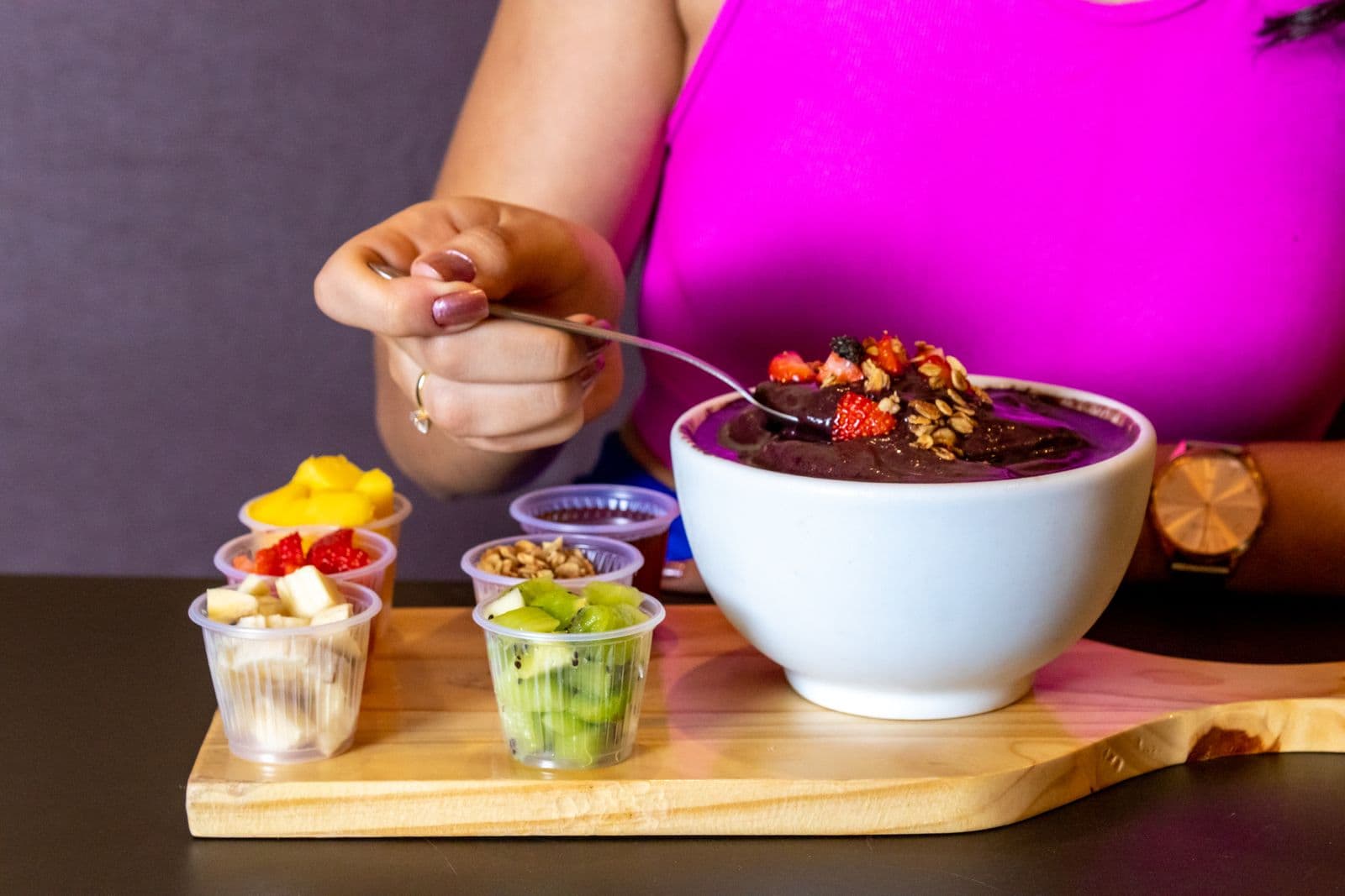 Woman preparing an açaí bowl with fresh fruit. Photo by Hiure Gomes Fernandes (Pexels)