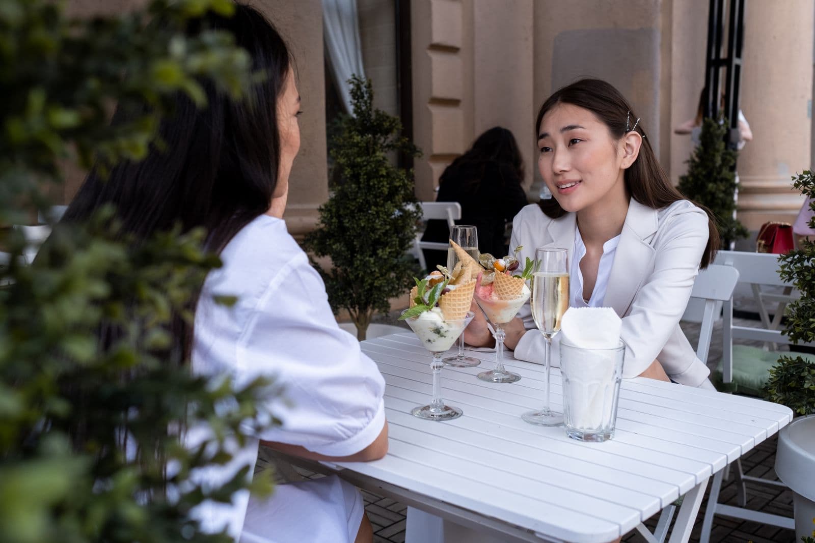 Two friends having ice cream on a terrace. Photo by Ron Lach (Pexels)